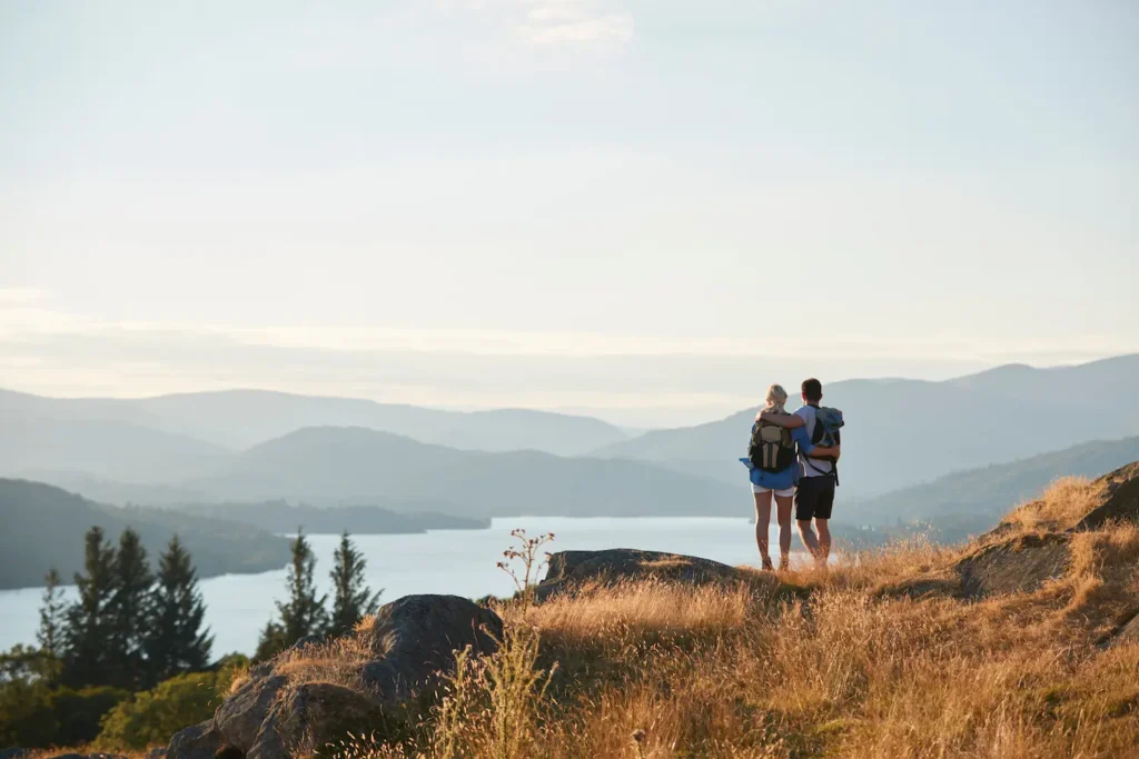 A couple with their arms around each other while they stare into the Columbia River Gorge.