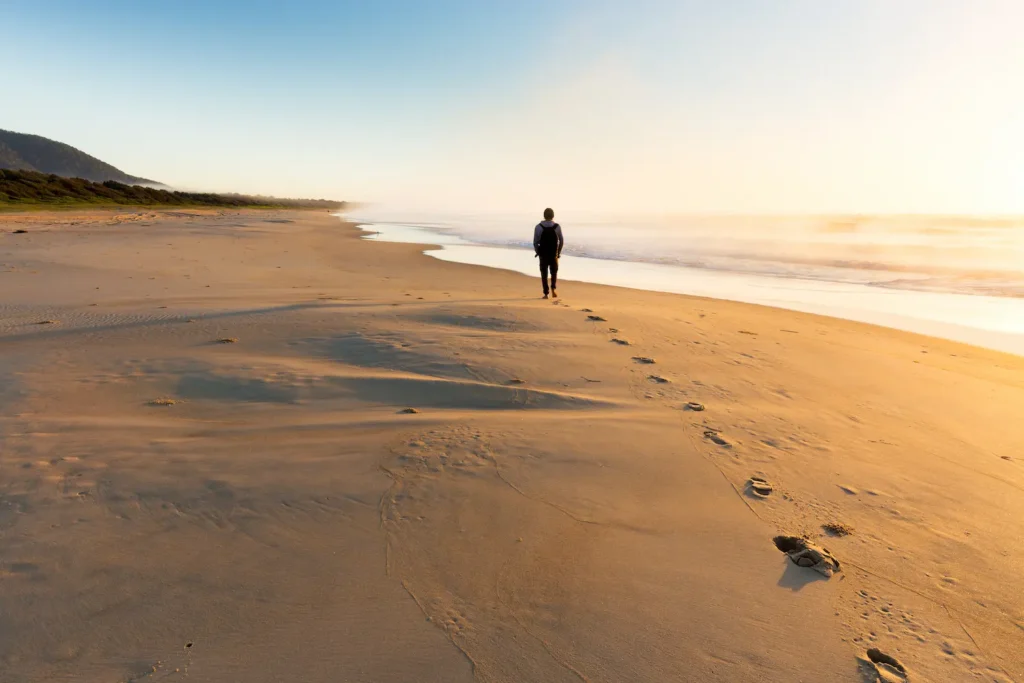 Man walking on the beach, relieving depression and anxiety symptoms through therapy