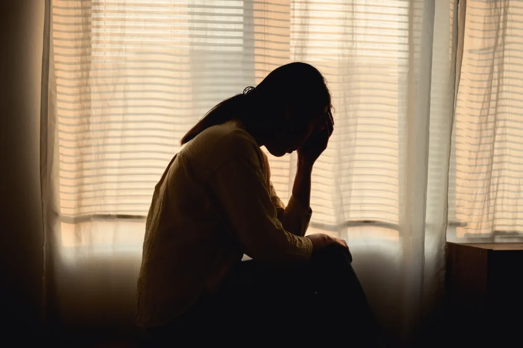 Woman alone in room experiencing symptoms of schizophrenia