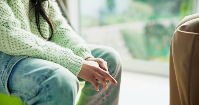 A girl wearing a green sweater in a therapy session